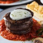 Filet mignon steak pizzaiola with garlic Parmesan butter and sauteed peppers and mushrooms.